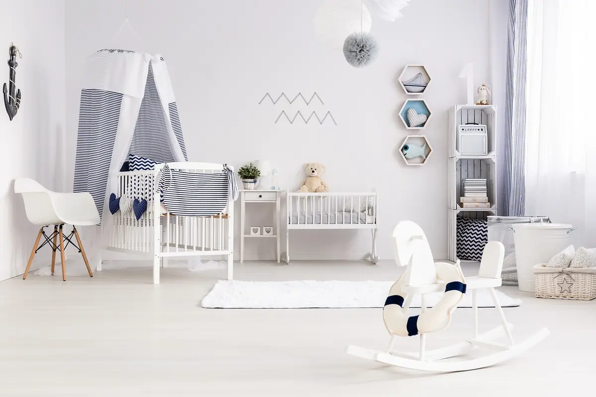 Bright nursery with a white crib, a canopy and a rocking horse